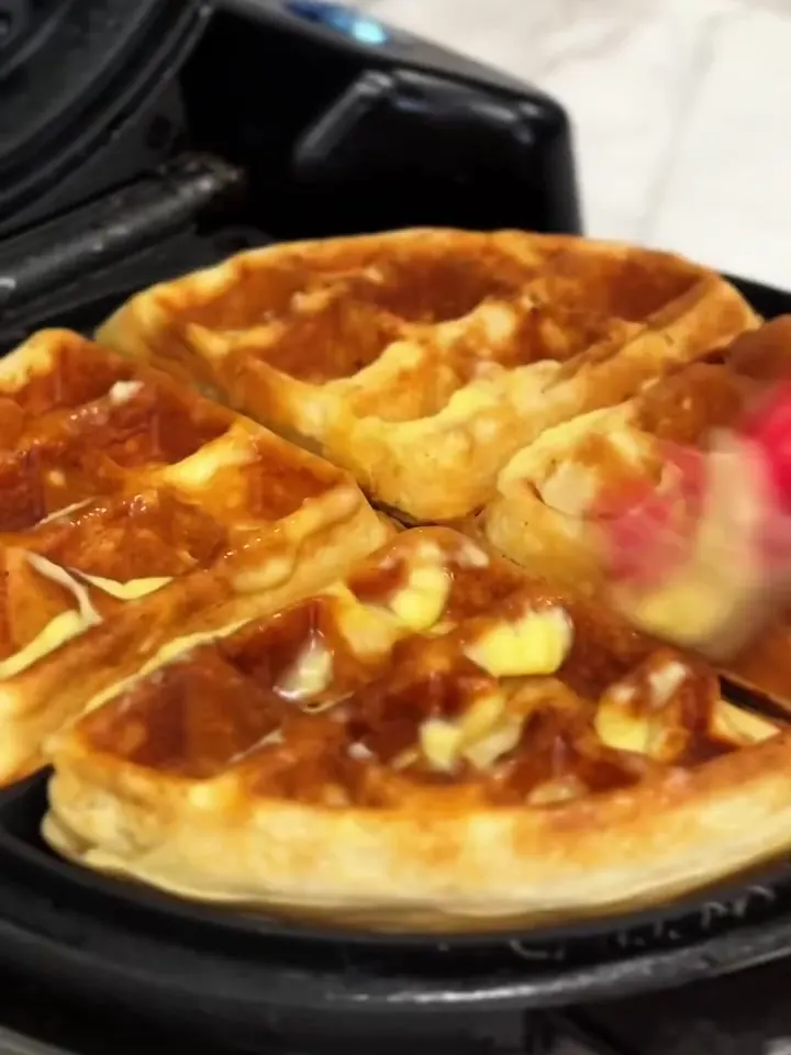 Waffles dourados saindo da máquina.