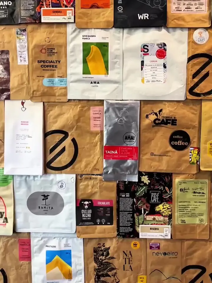 Parede coberta de embalagens de cafés especiais de diferentes torrefações.