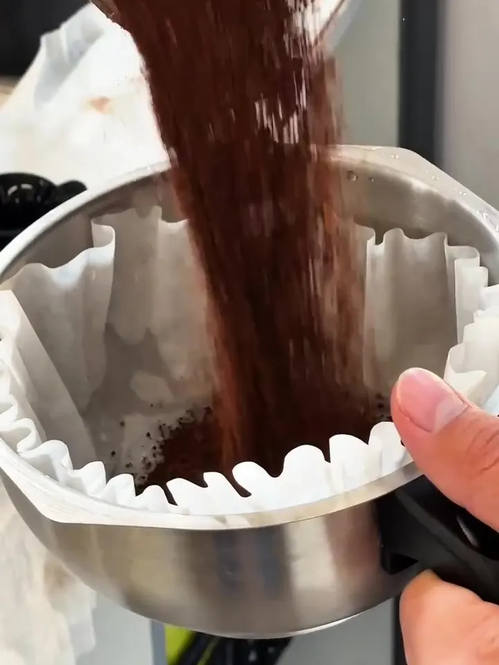 Café recém-moído caindo no filtro de papel.